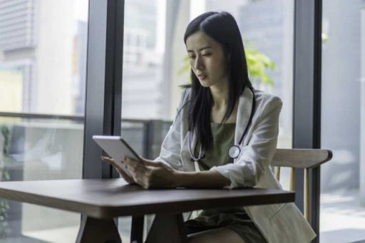 Asian Doctor Using Digital Tablet indoors.